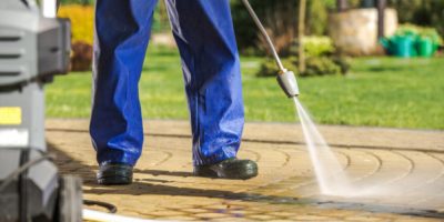 A man power washing a driveway